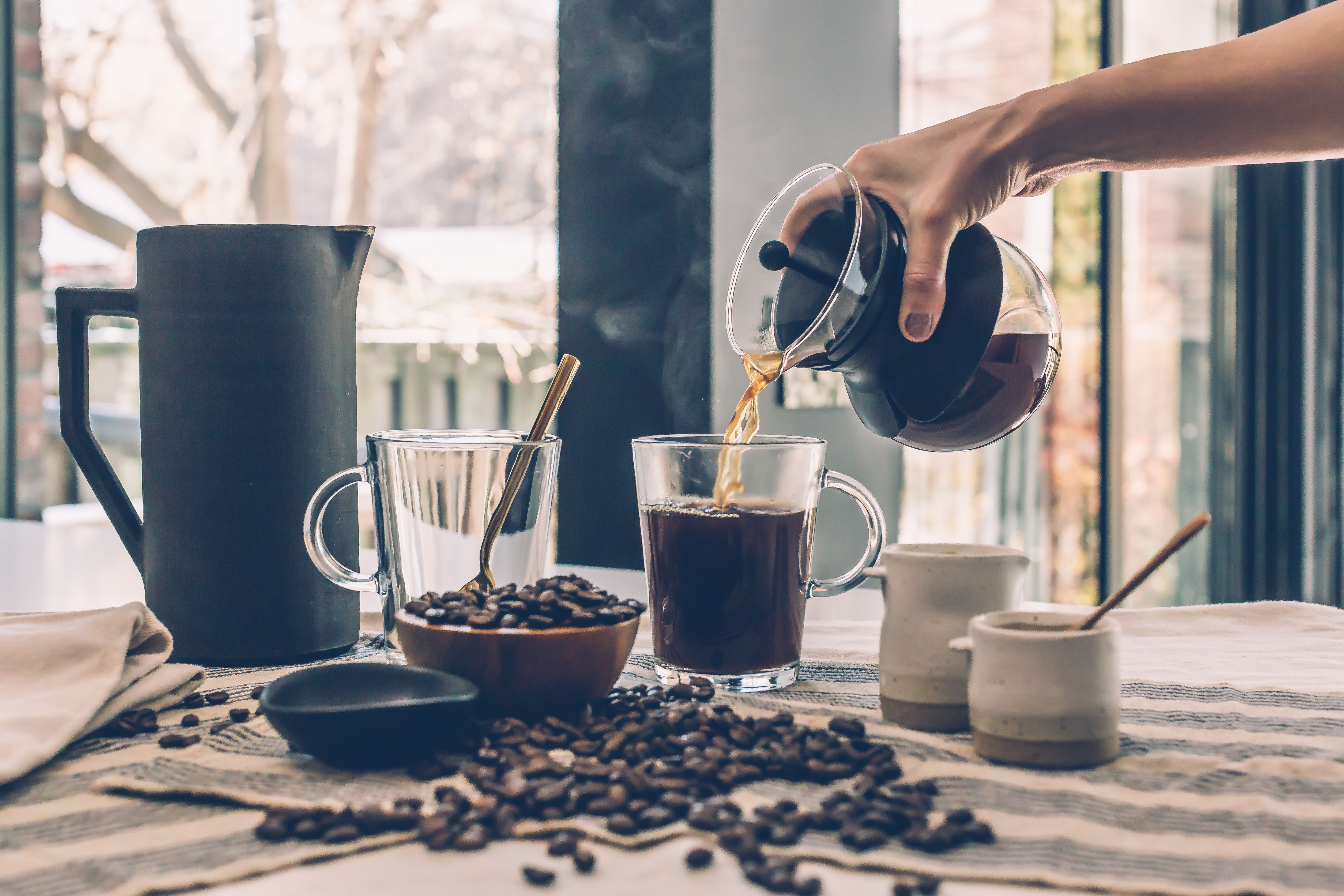 Hands pouring coffee — close, practical, unstyled
